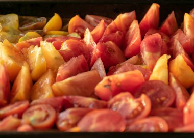 Dilimlenmiş domates tepsisi, farklı renkler ve şekiller, sonbahar hasat zamanı.