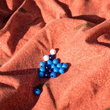 Yerdeki güzel pembe kumaş ve üstünde mavi beyaz toplar.