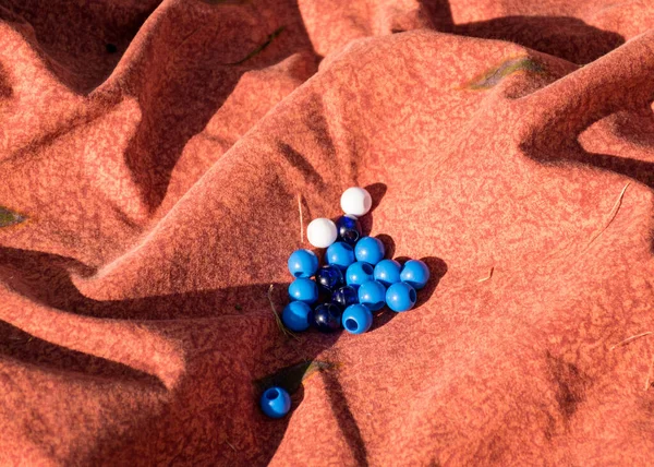 Yerdeki güzel pembe kumaş ve üstünde mavi beyaz toplar.