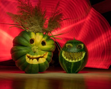 Cadılar Bayramı için hazırlanma, balkabağı oyma, Cadılar Bayramı için oyulmuş yeşil balkabakları, renkli ışık boyama arka planı, Cadılar Bayramı Jack o Fenerleri, sonbahar