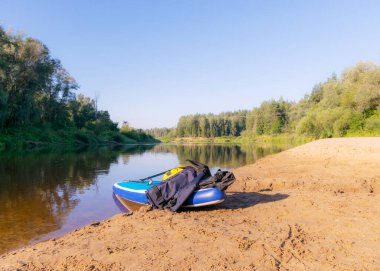 Nehirde güneşli bir gün, nehir kıyısında ayağa kalk, suda ağaç yansımaları, nehir suyunda yansıyan mavi gökyüzü, Gauja nehri, Letonya
