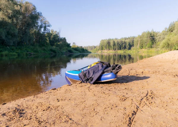 川の晴れた日には川の岸に板を張り水には木の反射川の水には青い空ラトビアのゴーヤ川 — ストック写真