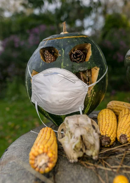 carved decorative pumpkin with face mask, coronavirus (covid-19) time, halloween, autumn time