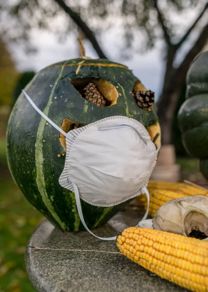 carved decorative pumpkin with face mask, coronavirus (covid-19) time, halloween, autumn time