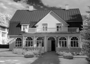 Ağaçları ve binaları olan siyah ve beyaz bir manzara. Kış gibi görünüyor. Letonya 'da kızılötesi filtre ile çekilmiş.