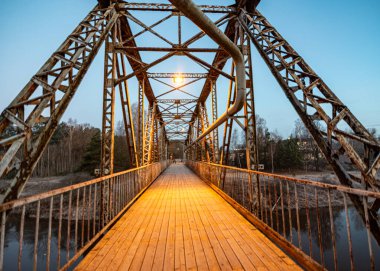 Gauja nehri üzerindeki demir yapı köprüsü, popüler yürüyüş noktası, şafak ışığı, Valmiera, Letonya
