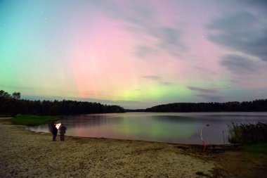 Gökyüzünde güzel kuzey ışıkları olan renkli fotoğraf gölün üzerinde kuzey ışıkları, Vaidavas Gölü, Letonya