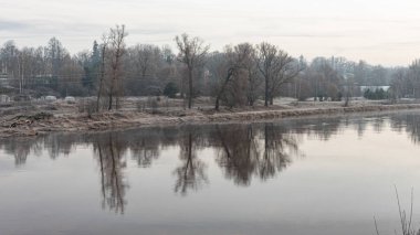 Güzel sabah ışıklarıyla manzara, sakin su yüzeyine yansıyan gökyüzü