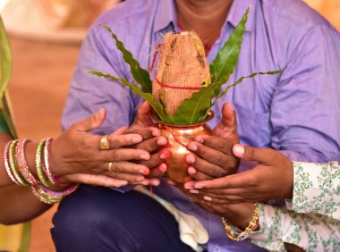 Hindistan cevizli bakır Kalaş ve elinde çiçek desenli mango yaprağı. Hindu pujası için gerekli.