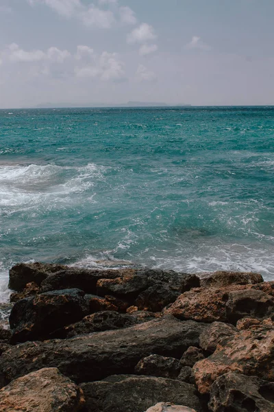 Playa rocosa en Mallorca, en verano en marea alta con las olas golpeando y rompiendo en la costa . — Foto de Stock