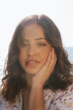 Genç latin kadın arka planda mavi deniz ile gülümseyen. T