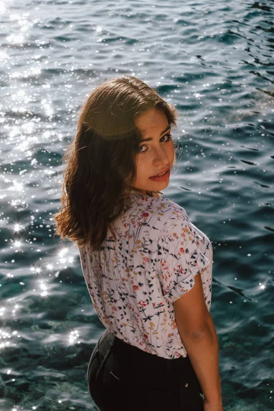 Young latin woman smiling with the blue sea in the background. T — Stock Photo, Image