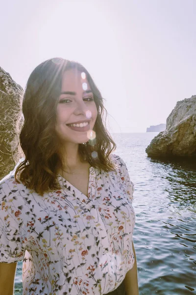 Genç latin kadın arka planda mavi deniz ile gülümseyen. T