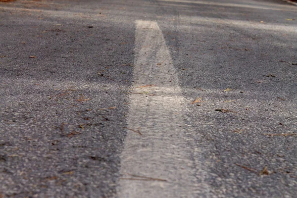 Černá asfaltová cesta a bílé dělící čáry — Stock fotografie