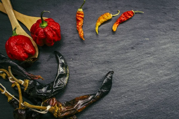 Najgorętsza papryka na świecie. Trinidad Scorpion Butch, tysiąc razy bardziej pikantny niż Hawana. Na czarnym tle łupek, z naturalnym światłem. Pikantne ciemne jedzenie koncepcja. — Zdjęcie stockowe