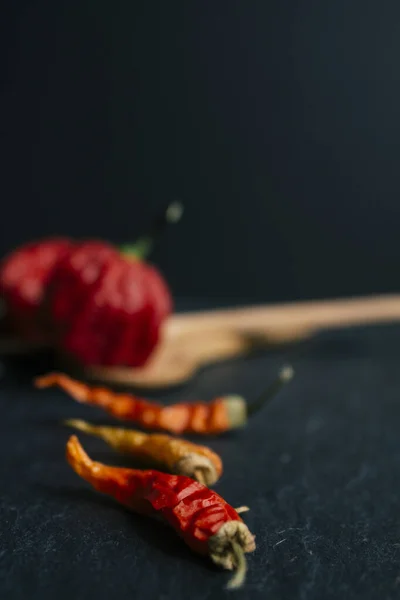 Hottest pepper in the world. Trinidad Scorpion Butch, thousands of times more spicy than Habanero. On black slate background, with natural light. Spicy dark food food concept.