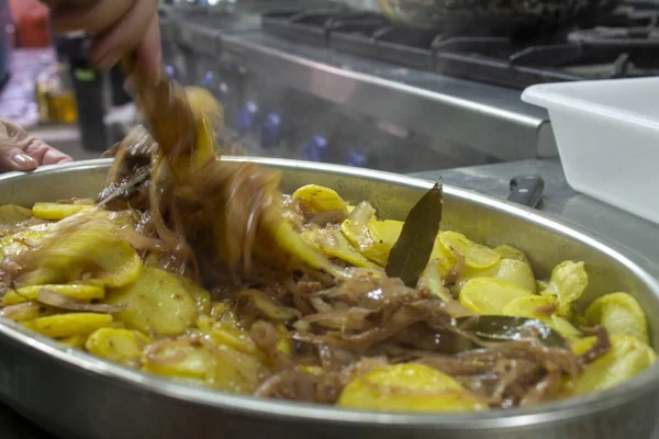 Cocinar preparando patatas pobres, típicas de España con patatas y cebollas . —  Fotos de Stock