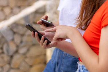 İki genç kız cep telefonuyla birbirlerine sosyal ağ kurmayı öğretiyor, sosyal ağları paylaşma konsepti ve iletişim dijital detoks.