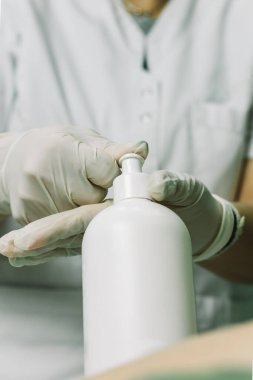 Eldivenli eldiven ve bir şişe nemlendirici masaj için hazırlanıyor. Spa konsepti.