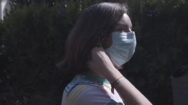 Bahçedeki covid 19 salgınından sonra genç kızın maskesini çıkardığı video. Yeni normal genç adamın maskesini çıkarıyorum. Evden çıkmanın keyfini çıkarıyorum..