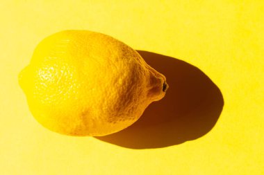 İzole edilmiş sarı arka planda limon. Yiyecek ve hasat toplama kavramı.