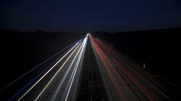 高速道路の暗闇に輝く動きの夜の都市のシーンぼやけた光のトラック. ストック画像