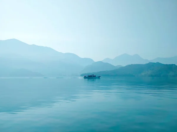 Grande lago azul com navio solitário pela manhã Fotos De Bancos De Imagens Sem Royalties