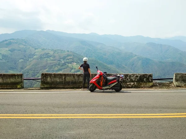 Menina com sua scooter desfrutando de uma bela vista da paisagem das montanhas — Fotografia de Stock
