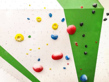 Yeşil kapalı tırmanma duvarı ve renkli tırmanma kolları soyut doku