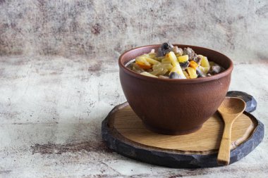 Gri bir arka plan üzerinde güzel bir kil plaka içinde et ve mantar ile Haşlanmış patates