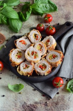 Peynirli rulo köfte ve siyah tabakta parçalara ayrılmış tatlı biber.
