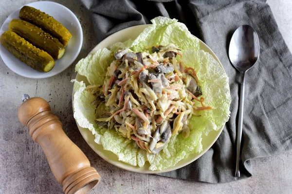 Marul yapraklı mayonez salatası klasik gri arka planda duran bir tabakta duruyor.
