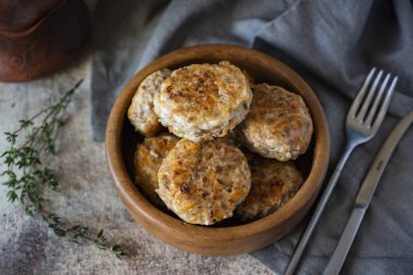 Gri arkaplanda ahşap bir tabakta domuz pirzolası