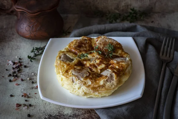 Gri arka planda beyaz tabakta köfteli omlet.