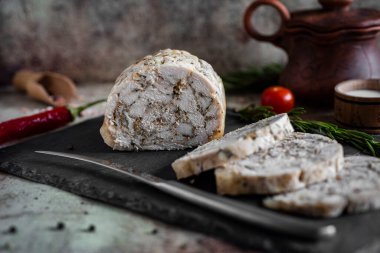 Gri arka planda güzel bir tabakta tavuk jambonu. Tavuklu börek.