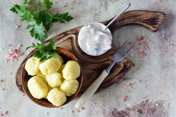 Patates gnocchi, gri arka planda krema soslu. Yukarıdan görünüşü