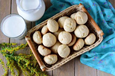 Tahta bir masada hasır sepetin içinde sünger kekleri. Yukarıdan görünüşü