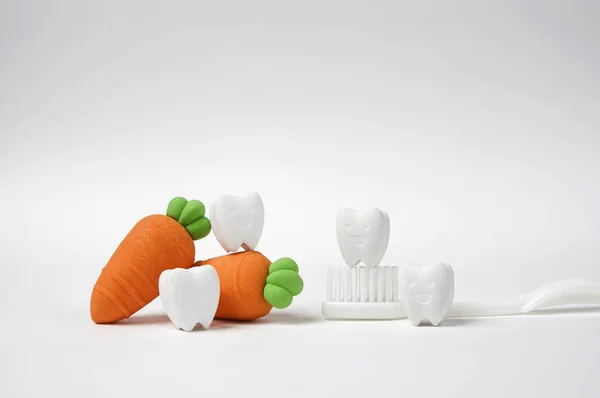 Smile Tooth Model with Carrot Model , and White Toothbrush way to keep your teeth healthy