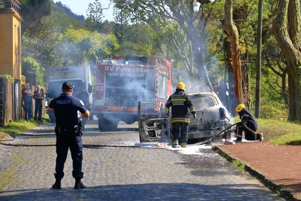 Polis ve itfaiye ile yolda yanan araba