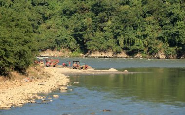 Nehir yanındaki bir kum madeninde çalışmakla meşgul olan bir grup İşçi.