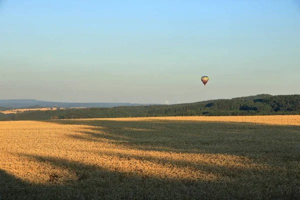 Globo de aire caliente sobre el campo con cielo azul frente a la saxonia Suiza —  Fotos de Stock
