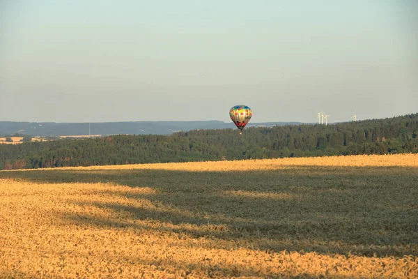 Balon na gorącym powietrzu na polu z błękitnym niebem przed Saksonii Szwajcarii — Zdjęcie stockowe