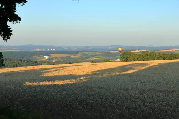 Globo de aire caliente sobre el campo con cielo azul frente a la saxonia Suiza —  Fotos de Stock