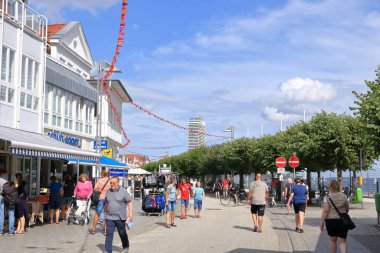 22 Ağustos 2020 - Travemuende / Almanya: Sıcak bir yaz gününde Baltık sahili boyunca yaya geçidi ve yürüyen turist manzarası