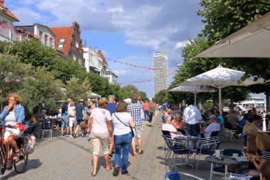 22 Ağustos 2020 - Travemuende / Almanya: Sıcak bir yaz gününde Baltık sahili boyunca yaya geçidi ve yürüyen turist manzarası