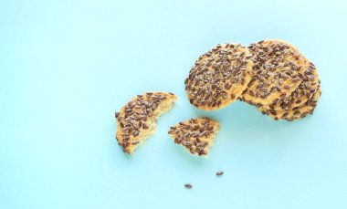Keten tohumlu vejetaryen çıtır kurabiyeler, turkuaz arka planda makro çekimler. Farklı tohumlu lezzetli sağlıklı ekmek fırını ürünü. Seçici odaklanma. süper yiyecekler