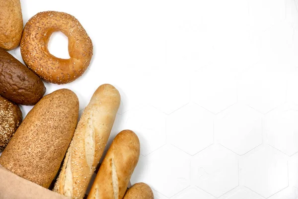 Diferentes tipos de pão fresco no fundo claro — Fotografia de Stock