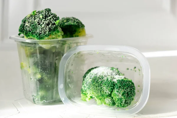 Verduras congeladas en las cajas de almacenamiento sobre el fondo blanco de hormigón con sombras. espacio de copia —  Fotos de Stock