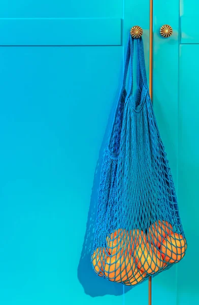 no plastic. oranges in a blue mesh bag