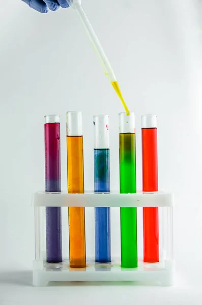 test tubes with multi-colored reagents on a white background. chemistry